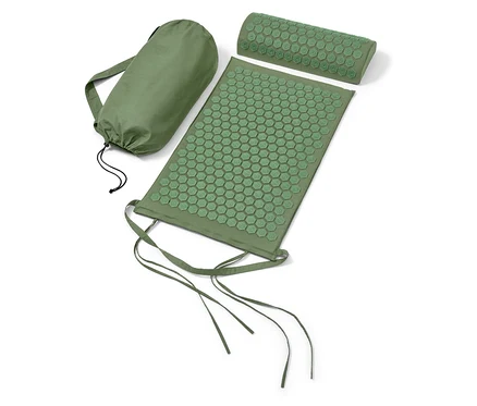 Un tapis d'acupression et un oreiller verts à côté d'un sac vert.