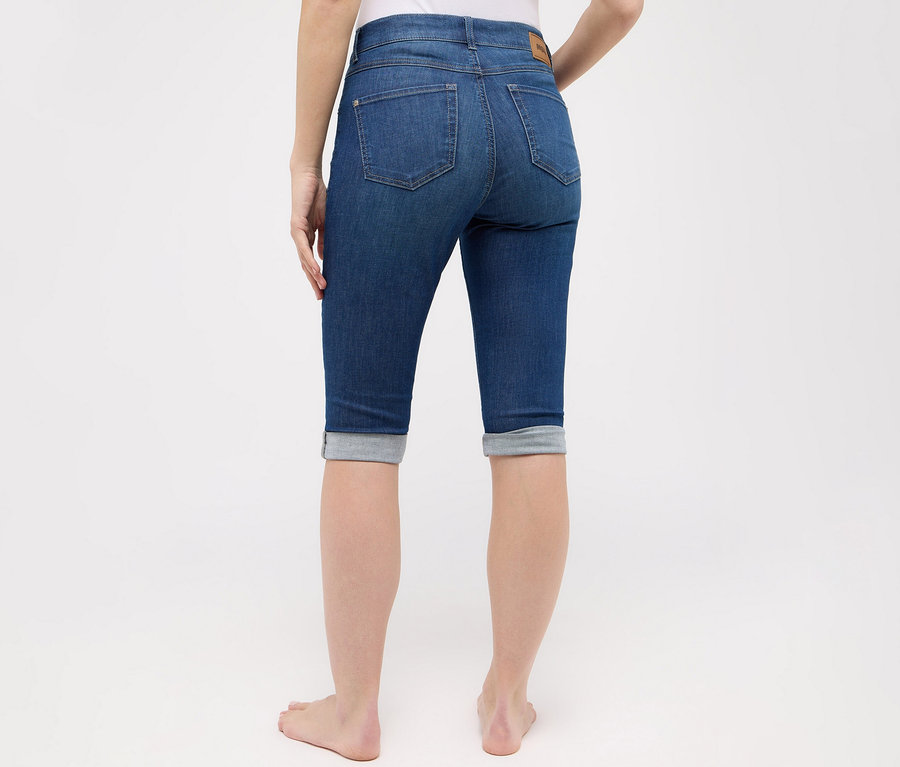 Femme vue de dos portant un jean «
Capri Turn-Up
» Angels, coupe étroite, bleu moyen.