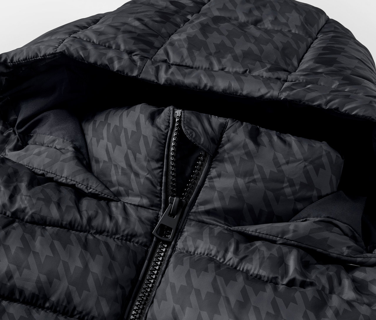 Gros plan sur une doudoune noire à capuche avec un motif pied-de-poule et une fermeture éclair partiellement ouverte.