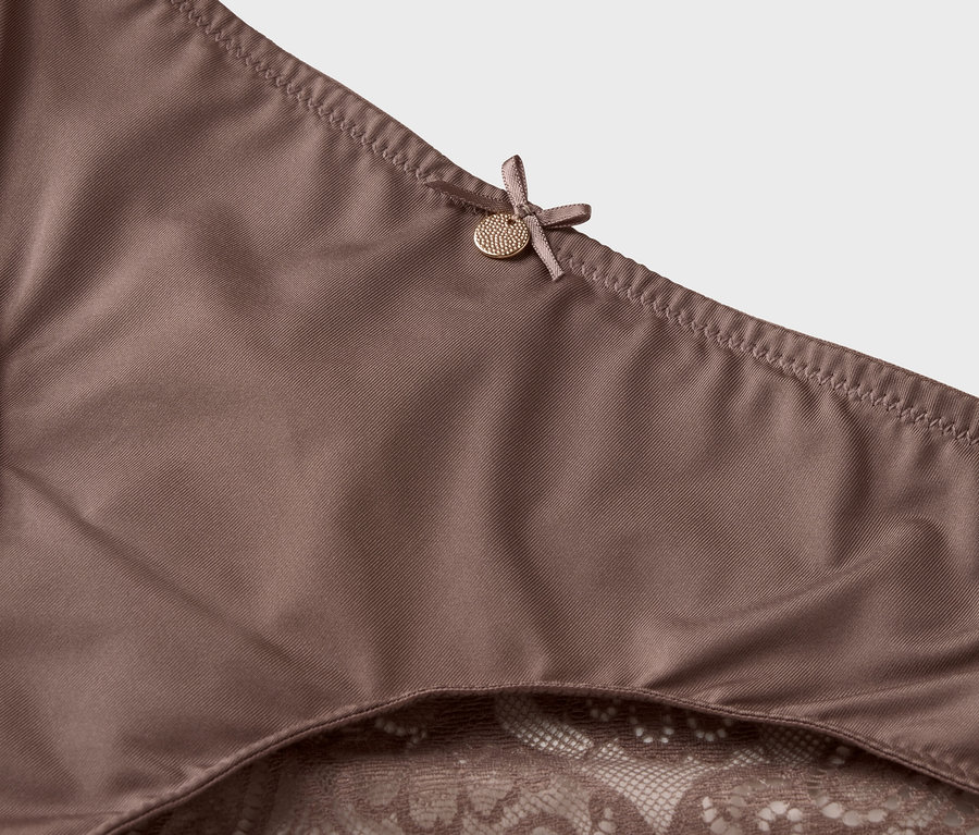 Gros plan sur un sous-vêtement marron avec des détails en dentelle et un nœud.