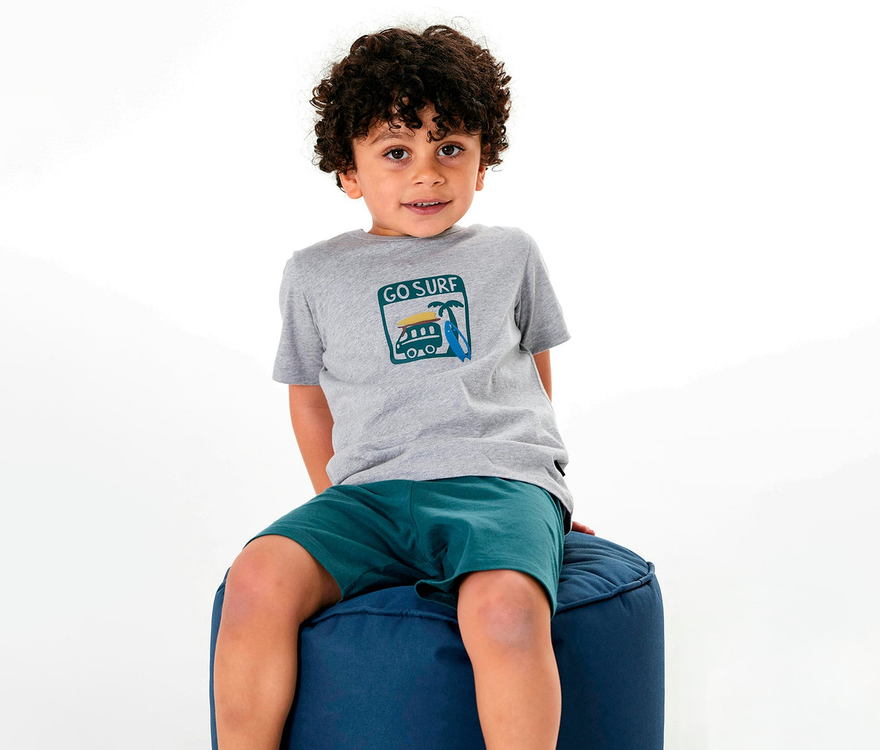 Garçon assis sur un tabouret portant un pyjama court pour enfant SCHIESSER.