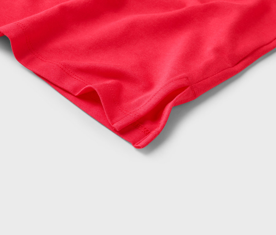 Gros plan d'un tissu rouge avec une fente à l'ourlet.