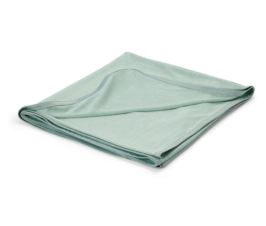 Couverture de bébé vert clair pliée sur fond blanc.