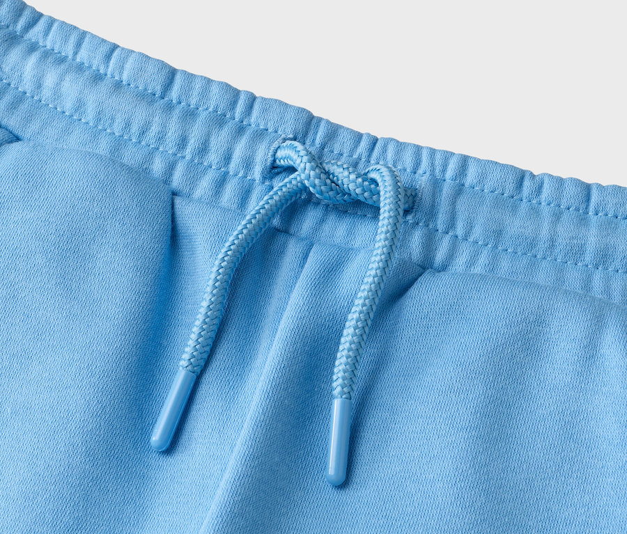 Gros plan d'un pantalon bleu clair avec cordon de serrage.