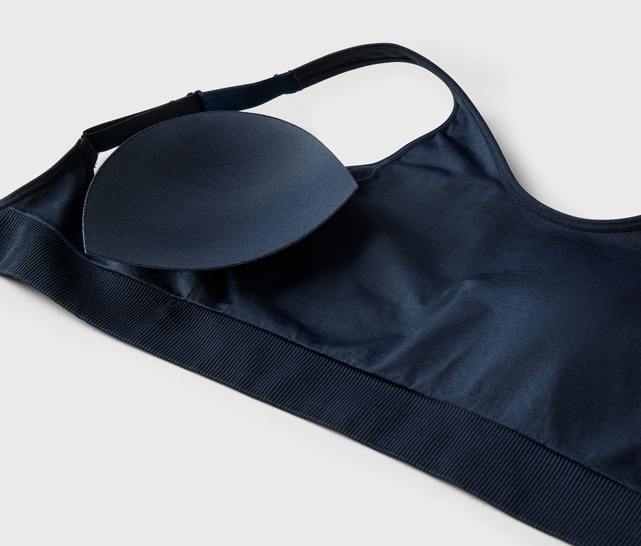 Vue détaillée d'un soutien-gorge de sport bleu marine avec coussinet amovible sur fond blanc.