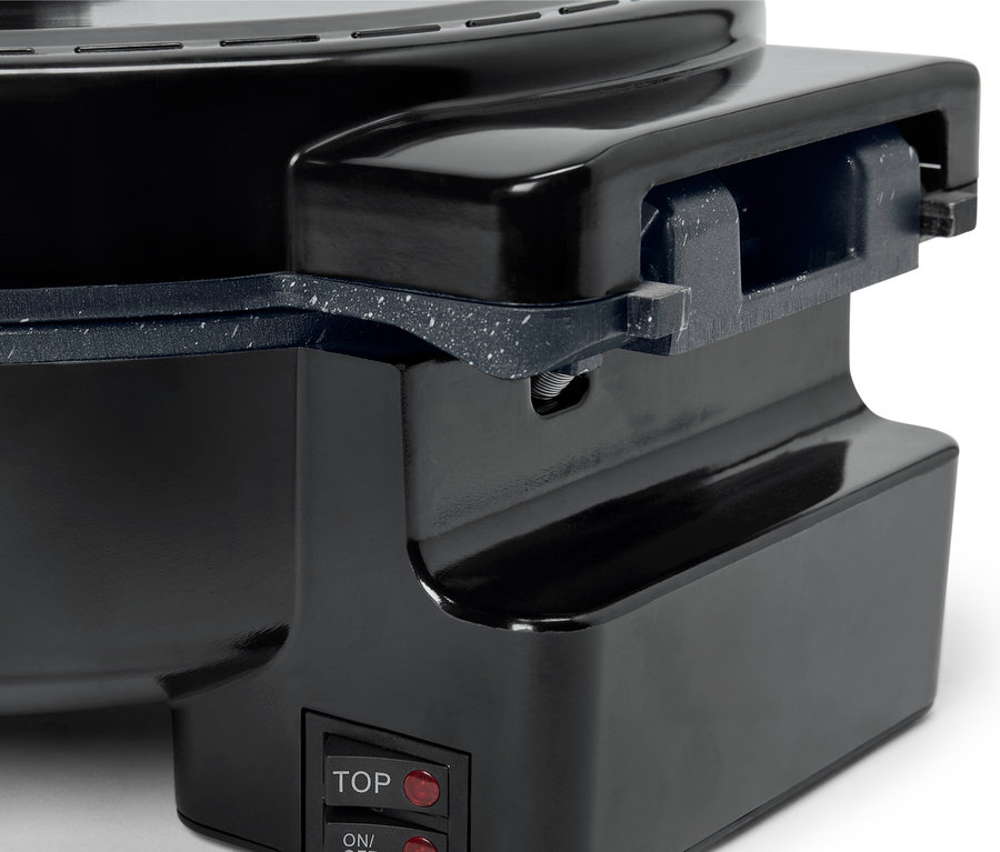 Gros plan sur un appareil de cuisine noir avec deux interrupteurs rouges étiquetés "TOP" et "ON/OFF".