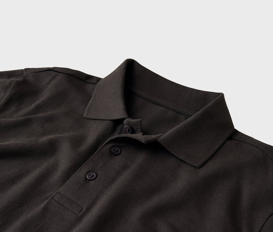 Gros plan d'un polo marron foncé avec un col et deux boutons.