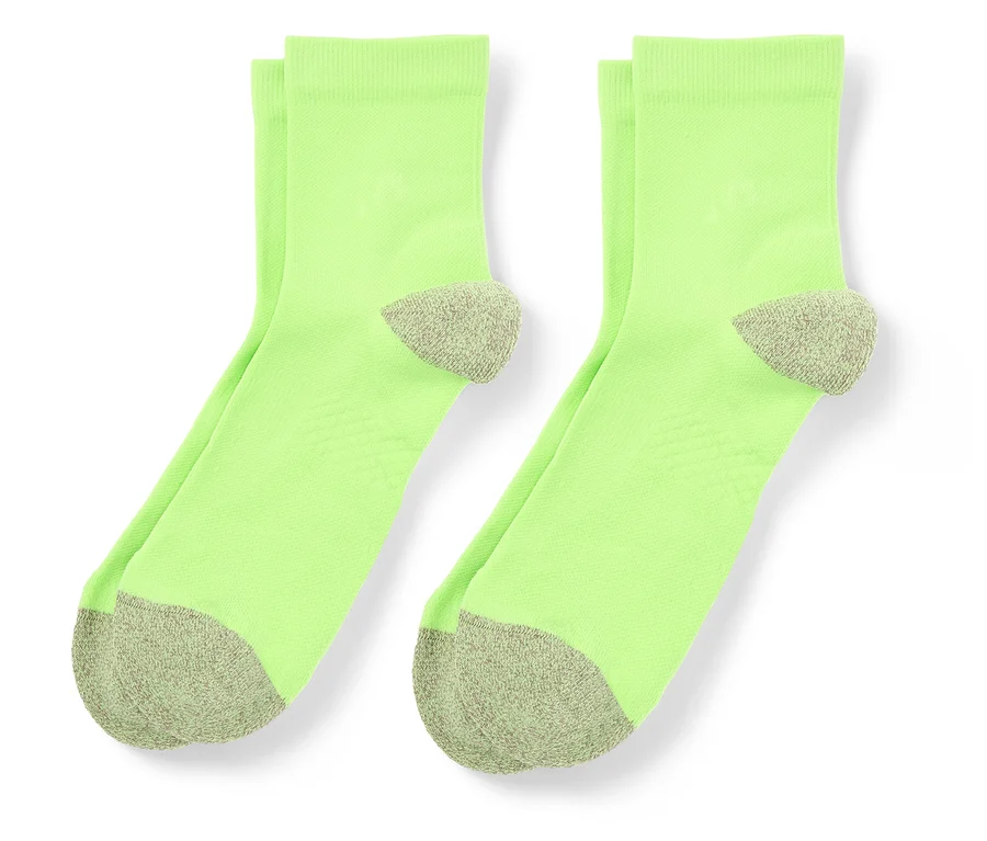 Deux chaussettes vert clair avec des bouts et des talons gris sont côte à côte.