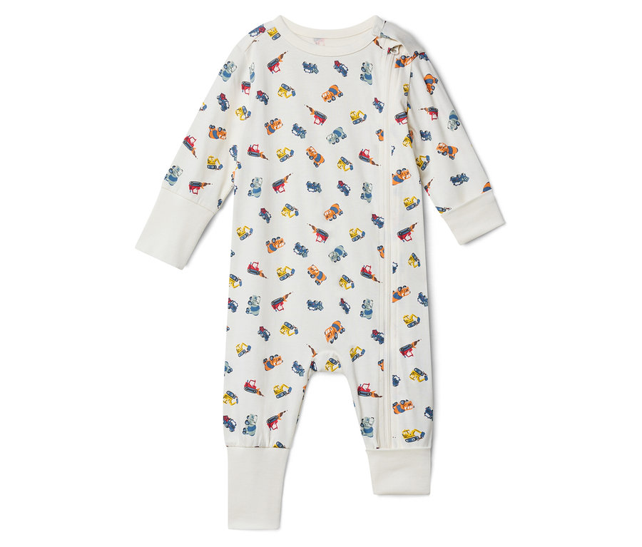 Un pyjama de bébé blanc avec un motif de camions de construction et une fermeture éclair à l'avant.