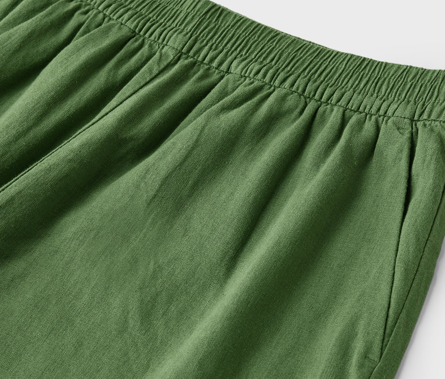 Gros plan sur un pantalon vert avec une taille élastique et une poche.
