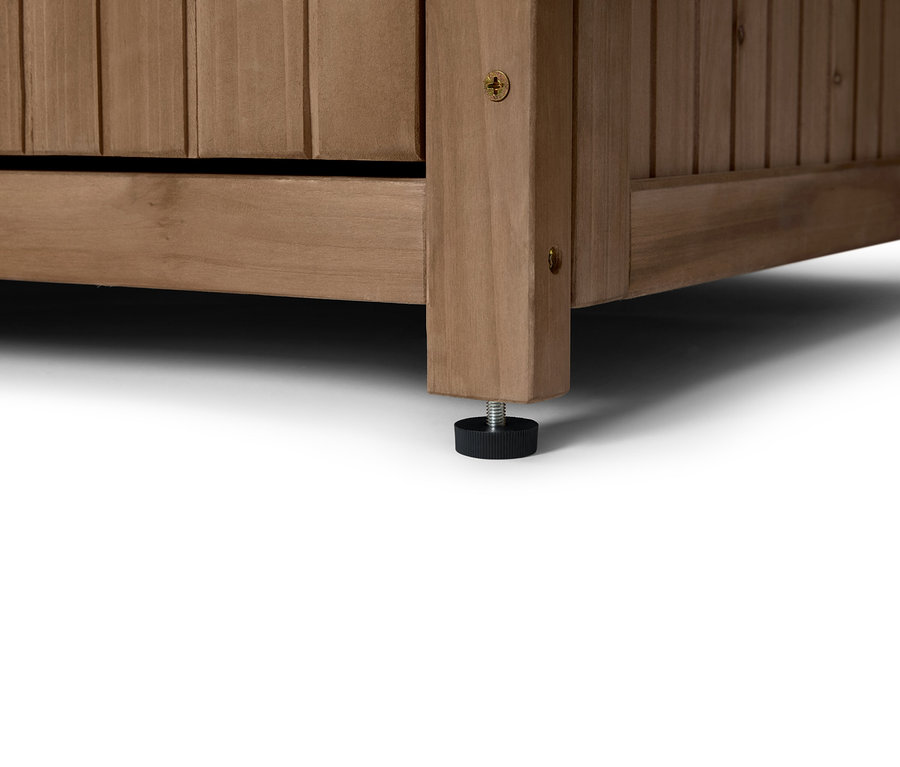 Gros plan sur le coin d'une armoire en bois avec un pied noir réglable.