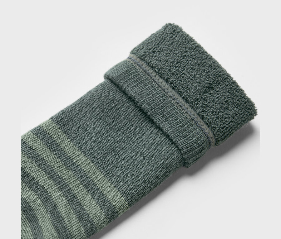 Gros plan d'une chaussette pour bottes en caoutchouc pour enfants (2 paires), motif camions, avec des rayures vertes et un ourlet retroussé.