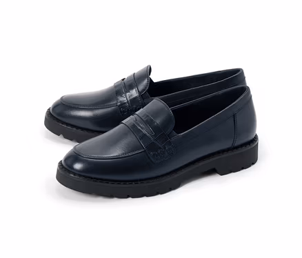Une paire de mocassins bleu marine avec une bride gaufrée façon crocodile et des semelles noires épaisses.