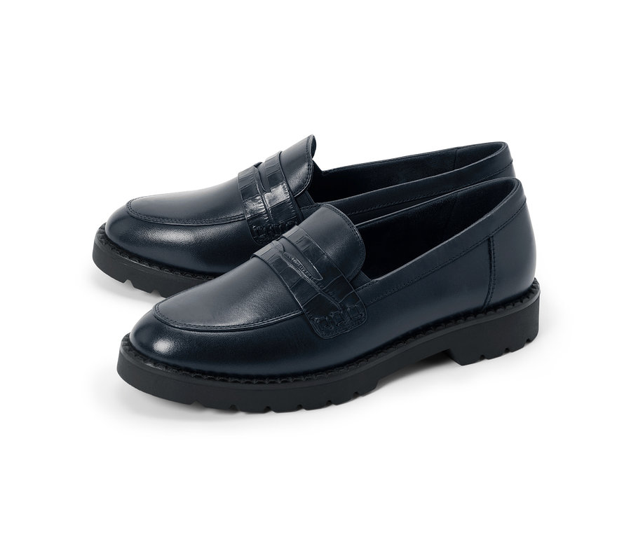Une paire de mocassins bleu marine avec une bride gaufrée façon crocodile et des semelles noires épaisses.