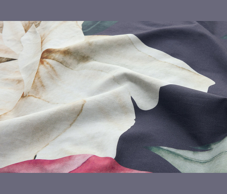 Tissu drapé avec un grand motif floral abstrait dans des tons crème, marron, bleu foncé, vert et rose.