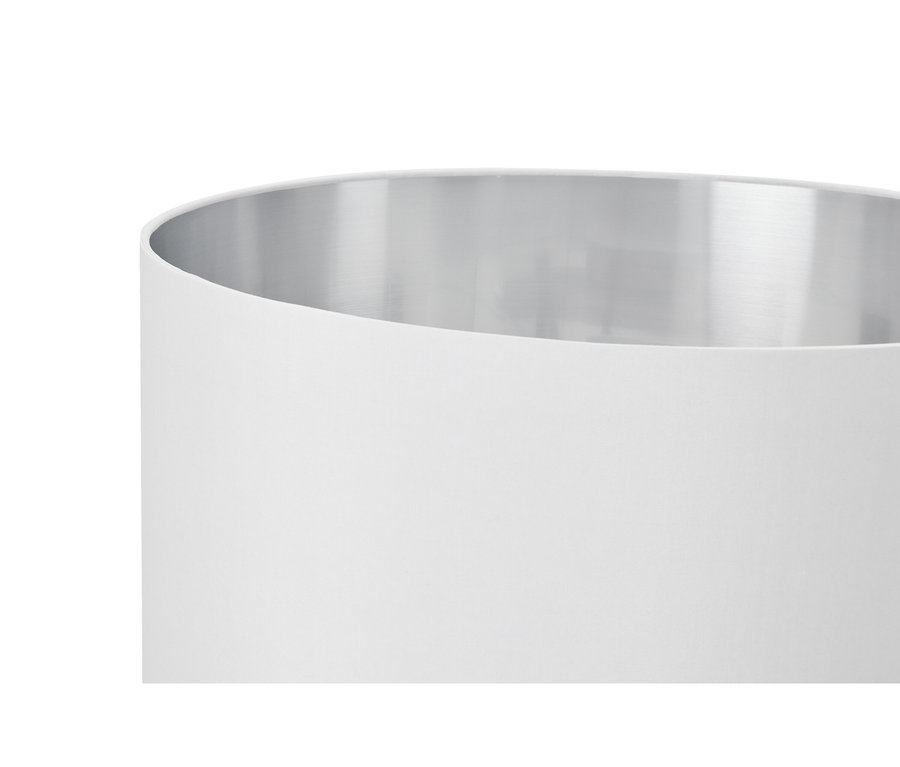 Gros plan d'un objet cylindrique blanc avec un intérieur argenté et réfléchissant et un extérieur blanc mat.