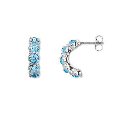 Gros plan d'une paire de boucles d'oreilles argentées avec chacune cinq pierres bleu clair.