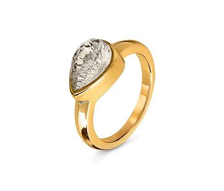 Détail d'une bague en or avec une pierre transparente en forme de larme.