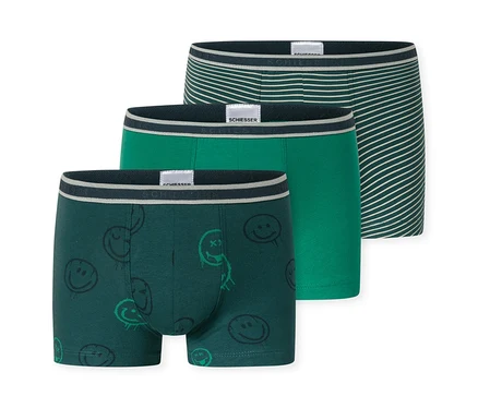 Trois shorts pour enfants SCHIESSER: un vert foncé à motifs de smileys, un vert moyen uni et un vert foncé à rayures blanches. Tous ont une ceinture SCHIESSER.