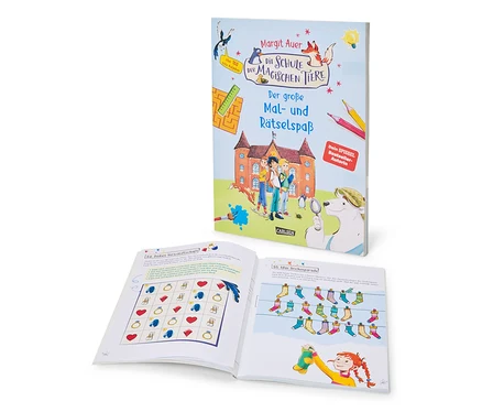 Le livre « L’école des animaux magiques – un grand plaisir de dessin et d’énigmes » (en allemand) est debout et montre sa couverture avec une école, des enfants et des animaux. Devant, un livre ouvert présente une page de grille de puzzle et une illustration d'une fille qui accroche des chaussettes colorées.