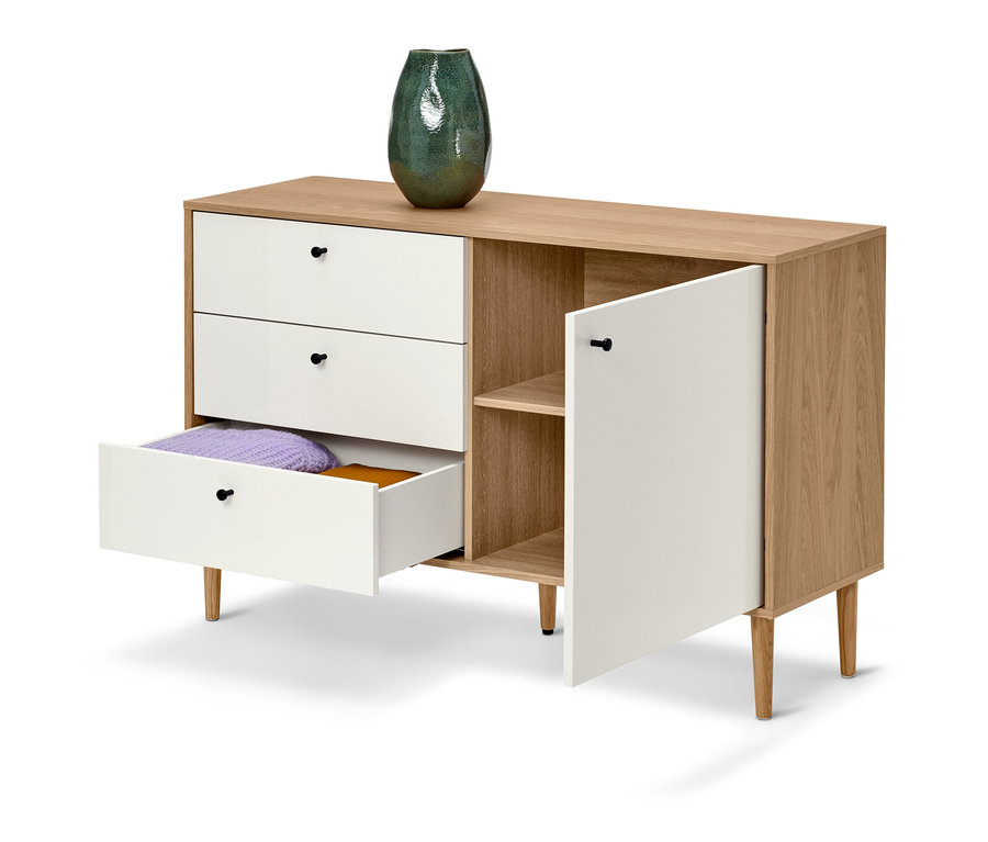 Commode blanche Bekeson avec tiroir ouvert, porte et vase vert sur le dessus.