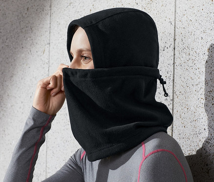 Femme ajustant une cagoule noire en micropolaire sur sa tête.