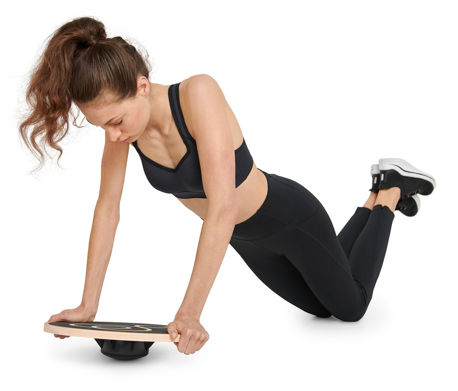Femme faisant des pompes sur un plateau d’équilibre.