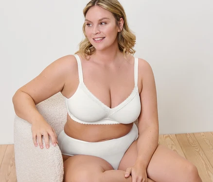 Femme assise dans un fauteuil portant un soutien-gorge souple.