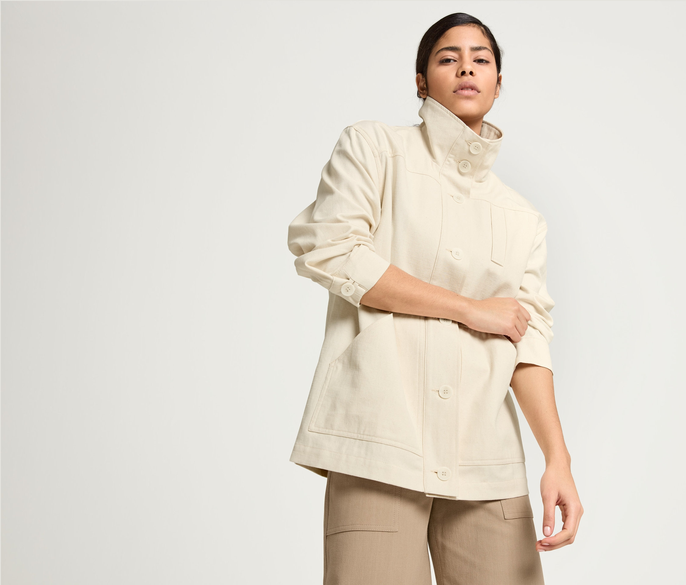 Femme posant en Parka NAH/STUDIO en coton non coloré et Jupe-culotte NAH/STUDIO en coton recyclé.