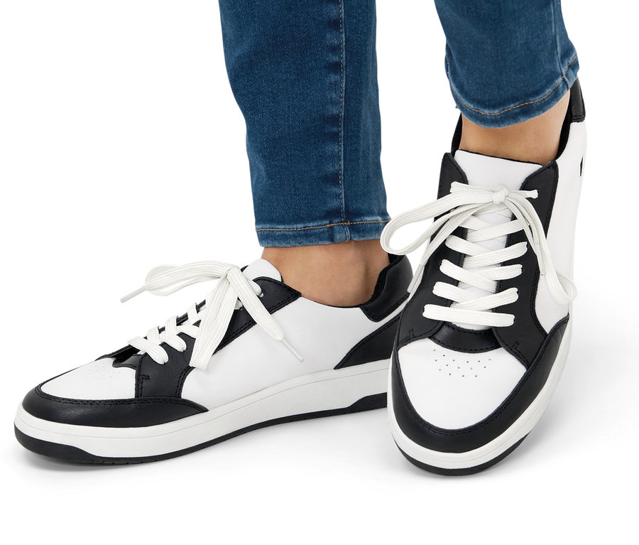 Jambes en jean et baskets en cuir.