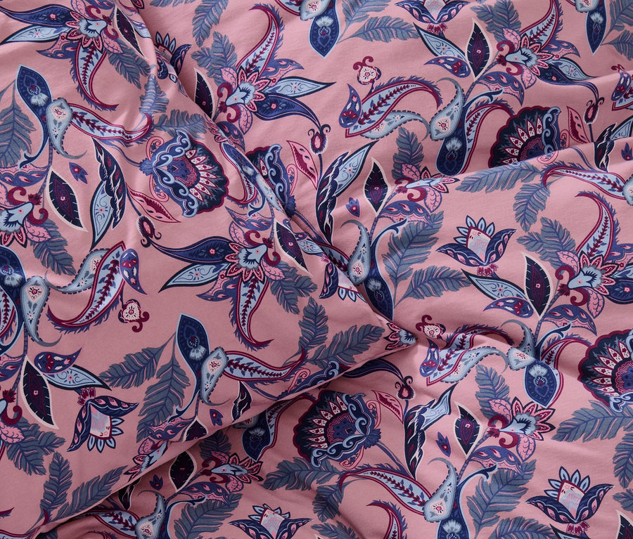 Gros plan d'une parure de lit en jersey d'hiver rose de taille standard avec un motif floral bleu.