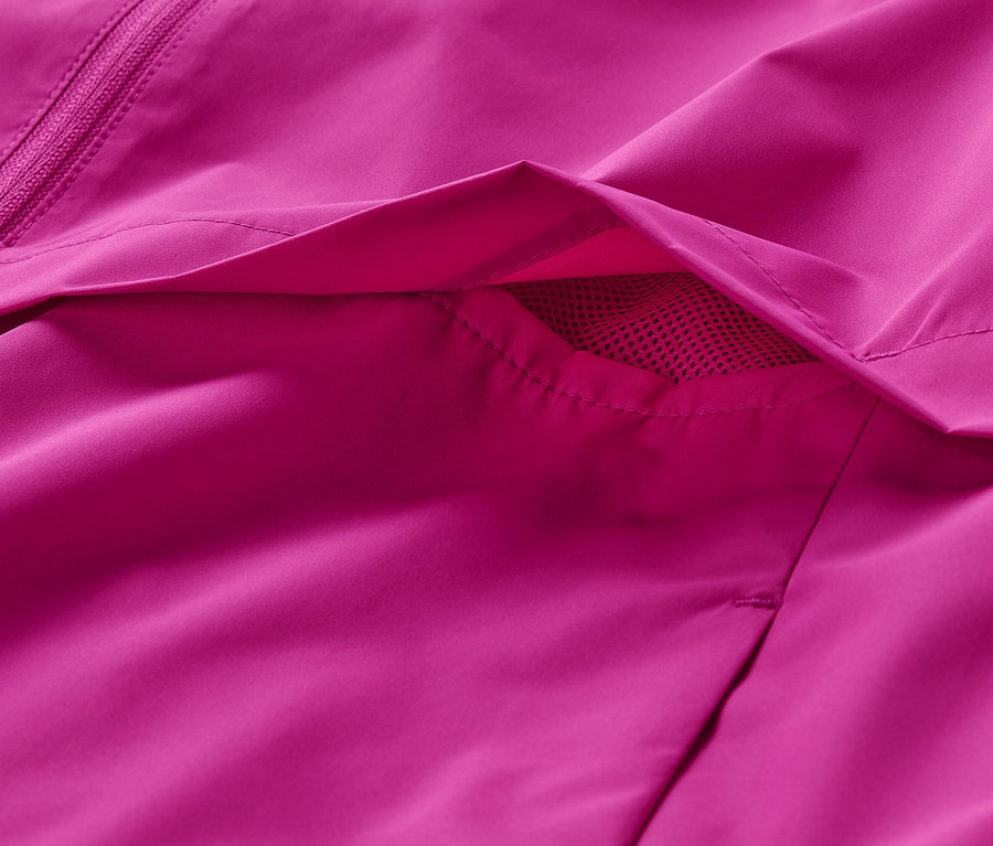 Détail d'une veste de sport coupe-vent rose avec une poche.