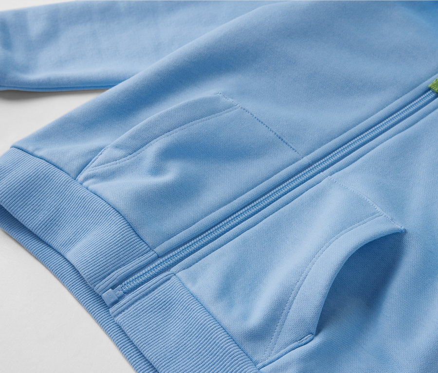 Gros plan sur une jaquette en sweat bleu clair pour enfant avec intérieur gratté, fermeture éclair et poches.