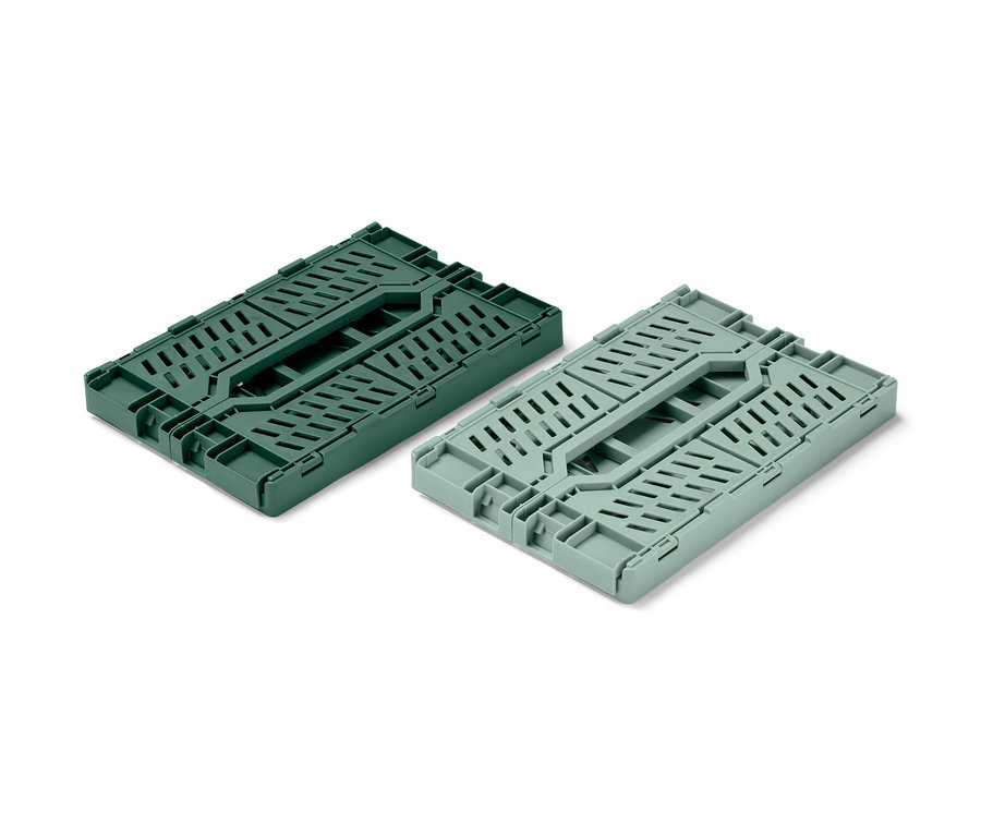Deux boîtes de rangement pliables, une vert foncé et une vert clair, sont pliées sur un fond blanc.