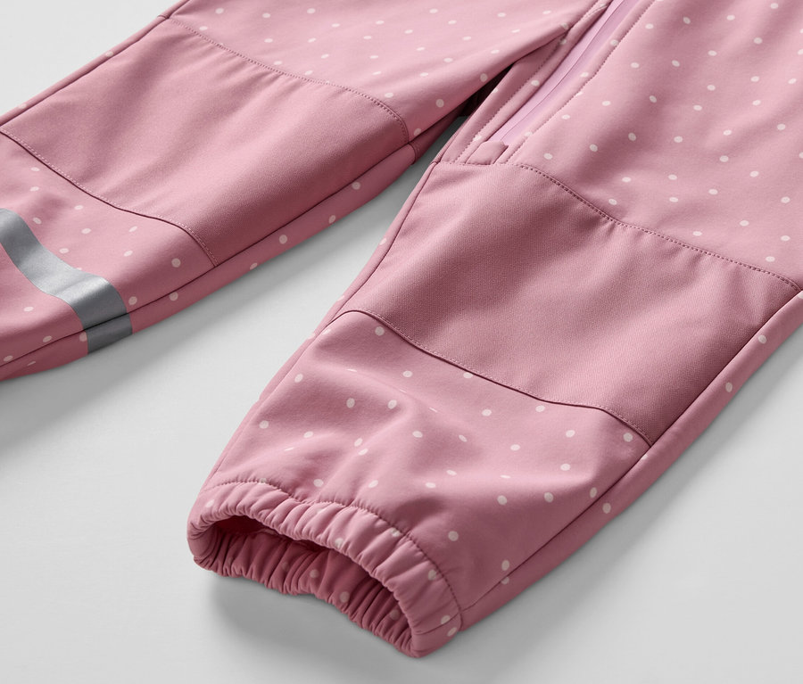 Gros plan sur une combinaison en softshell pour enfant avec des pois blancs.