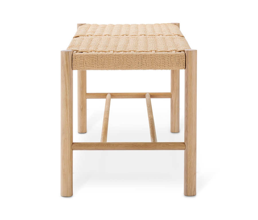 Un banc avec un siège tressé sur un fond blanc.