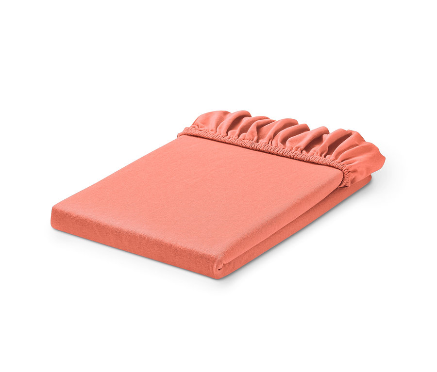 Drap-housse en jersey corail plié.