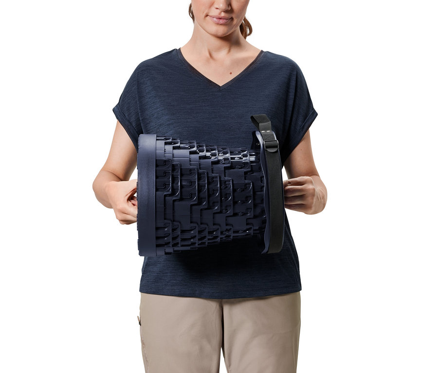 Femme tenant un tabouret de camping télescopique.