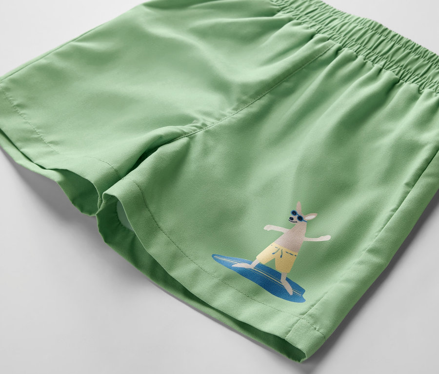 Boardshort vert pour enfant avec motif de surfeur.