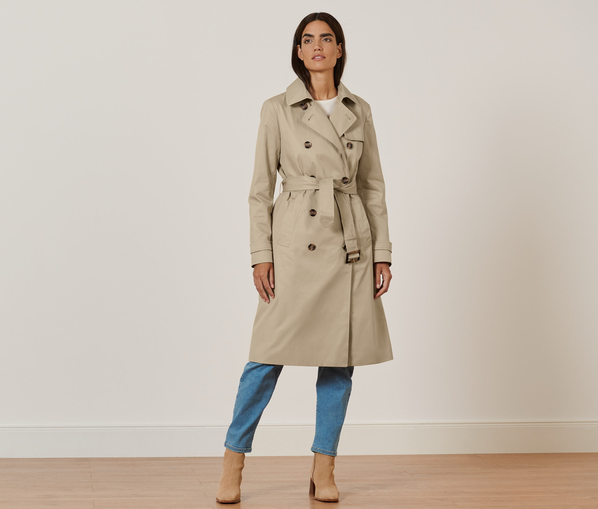 Femme posant en trench-coat beige.