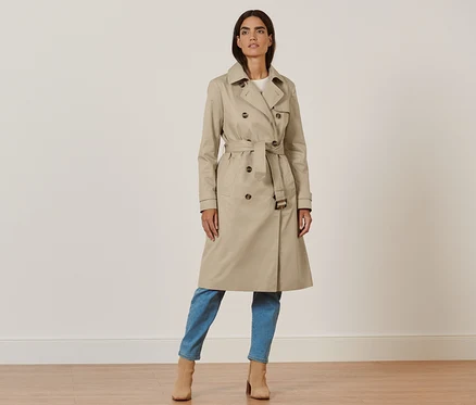 Femme posant en trench-coat beige.