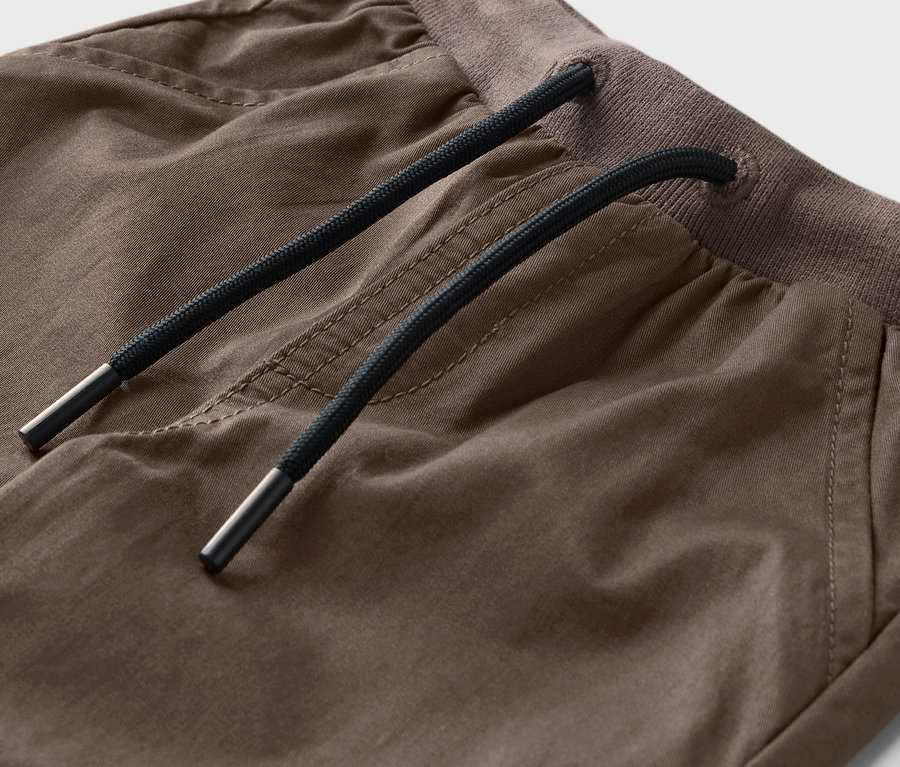 Gros plan sur un pantalon à enfiler pour enfants – Coupe «
Anton » avec cordon de serrage marron.