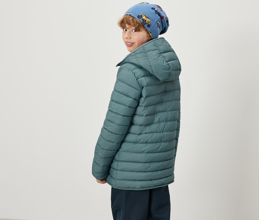 Garçon portant un bonnet bleu avec un imprimé de voiture et une veste matelassée et softshell 2-en-1 verte pour enfants, regardant par-dessus son épaule.