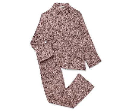 Un pyjama rose à manches longues et un pantalon à motifs sur un fond blanc.