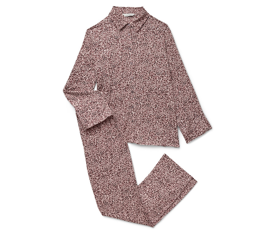 Un pyjama rose à manches longues et un pantalon à motifs sur un fond blanc.