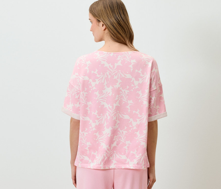 Femme portant un sweatshirt imprimé rose.