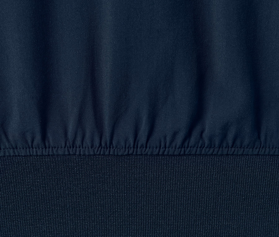 Gros plan sur une blouse bleu marine à bords côtelés.
