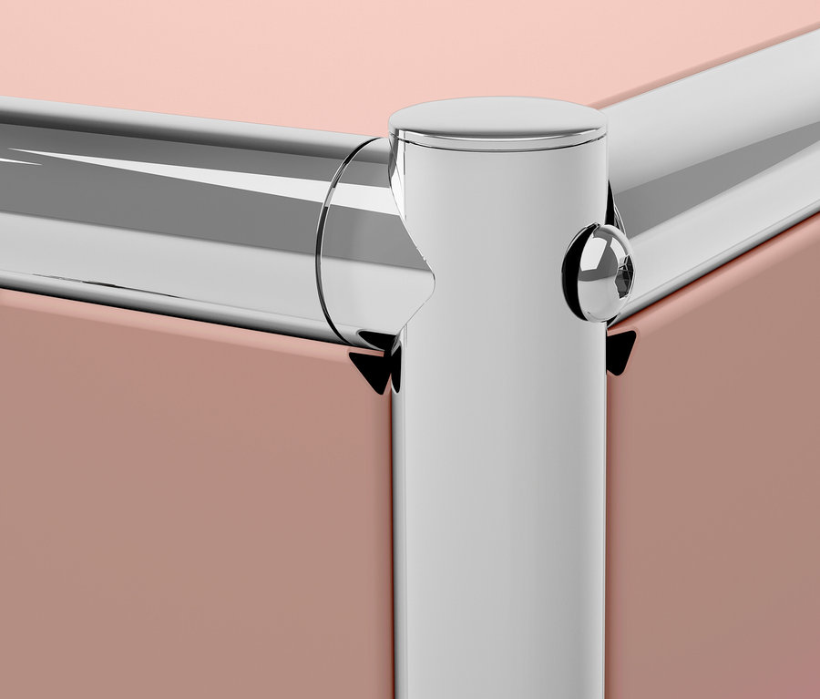 Détail d'un coin de meuble avec des panneaux roses et des bordures métalliques argentées.