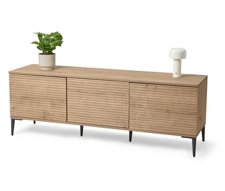 Buffet en bois clair avec plante en pot et lampe.