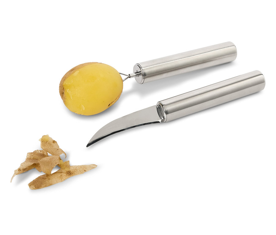 Une pomme de terre sur un éplucheur et un couteau à légumes à côté des épluchures.